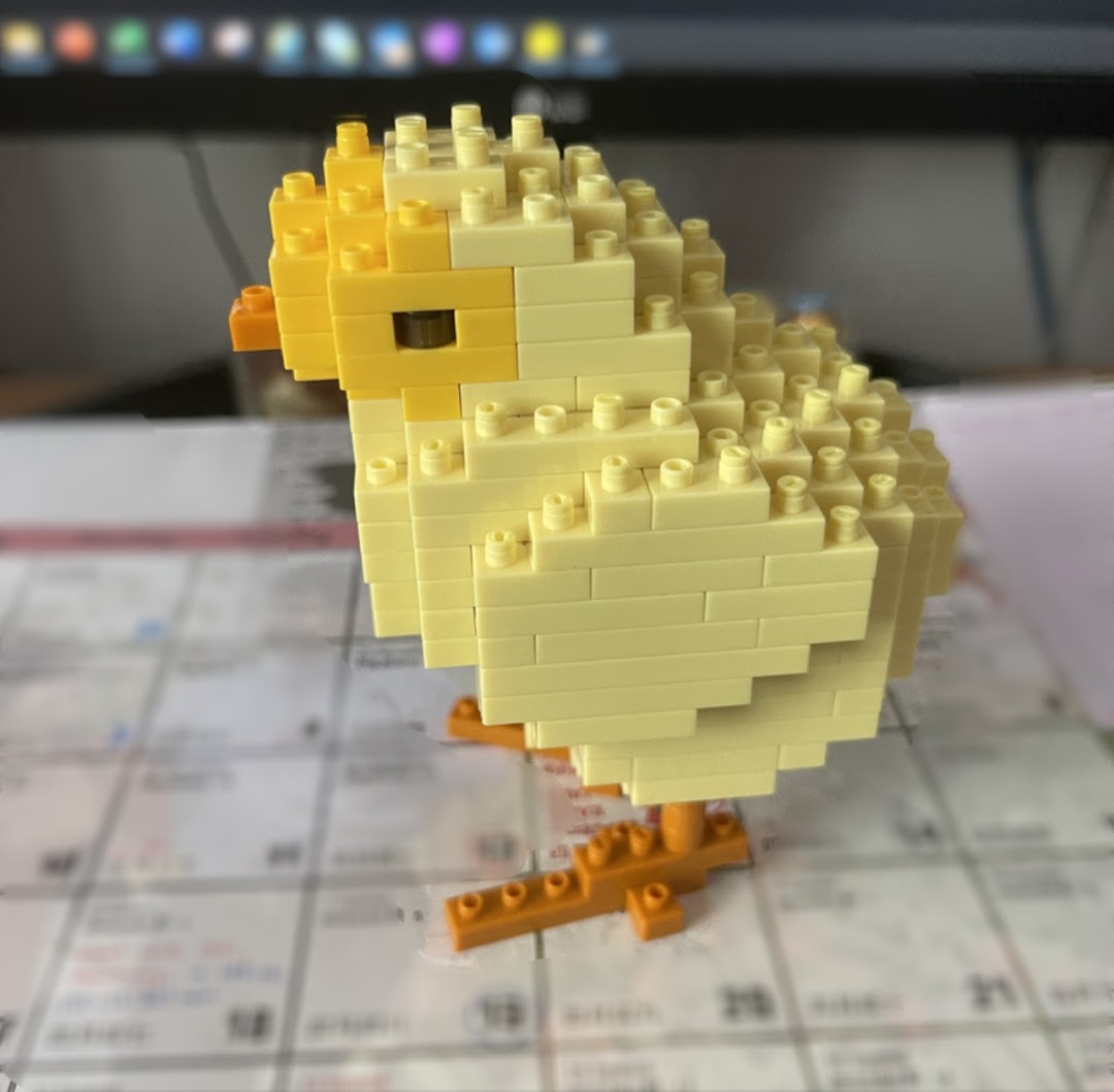 A cute yellow chick figure made from building blocks, showcasing a creative product.
