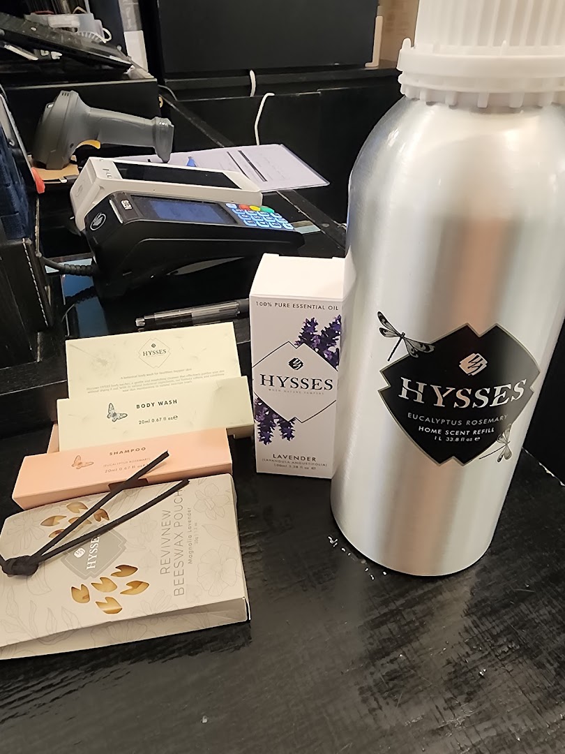 Various HYSSES home scent and personal care products, including essential oils and body wash, displayed near a payment terminal.