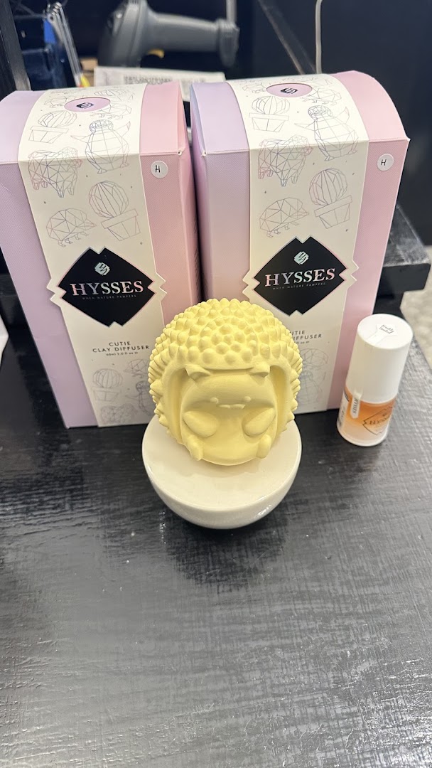 Close-up of HYSSES home scent products, including a 'Cutie Clay Diffuser' and essential oil.