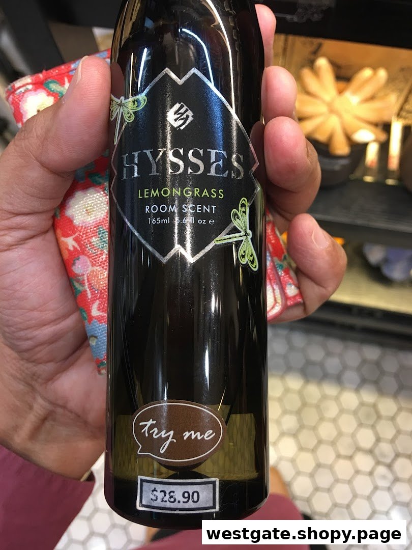 A hand holds a black bottle of HYSSES Lemongrass Room Scent with a price tag.