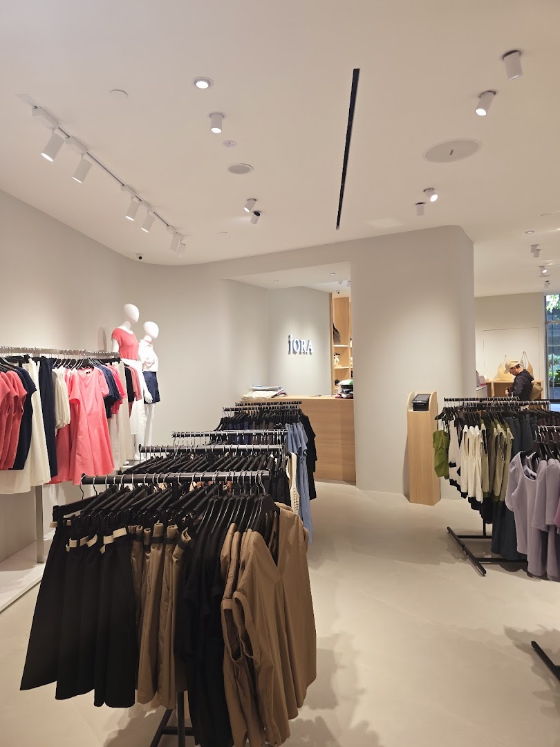 An interior view of the iORA clothing store, featuring racks of apparel and mannequins.