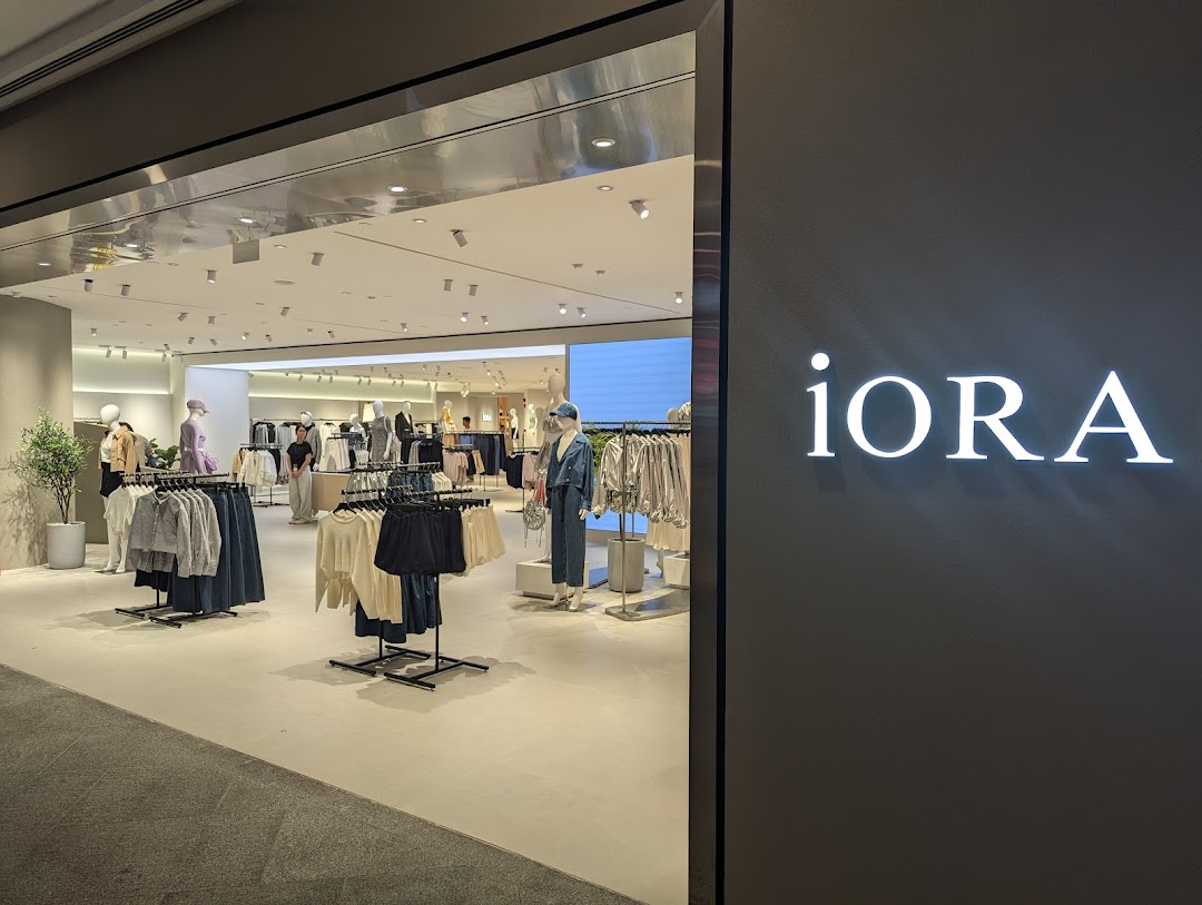 The entrance of iORA Westgate, showcasing a brightly lit interior with modern women's clothing on display.