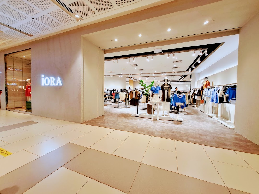 The bright and inviting entrance of the iORA fashion store, showcasing clothing displays and mannequins.