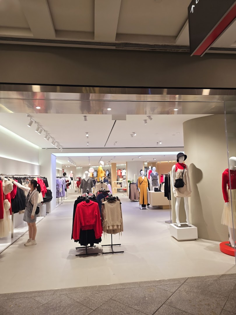The inviting entrance of a modern fashion boutique, showcasing stylish apparel on mannequins and racks.