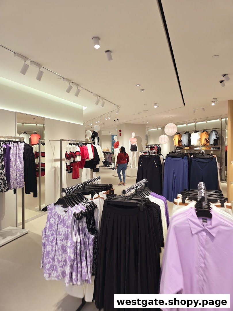 Interior view of a brightly lit clothing store with racks of women's apparel and mannequins.
