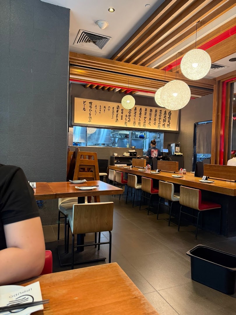 An inviting interior shot of Ippudo Westgate, showcasing its modern dining area and open kitchen.