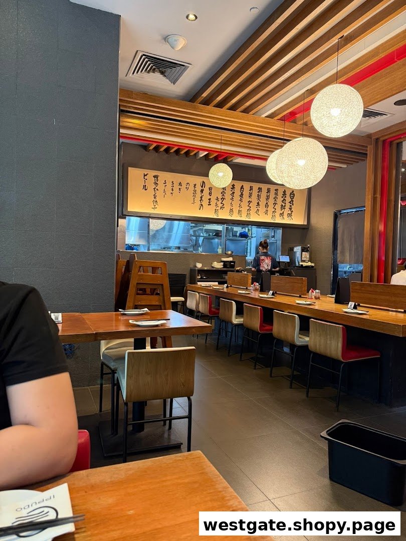 An inviting interior shot of Ippudo Westgate, showcasing its modern dining area and open kitchen.