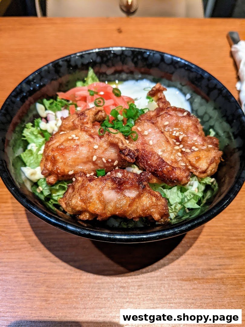 A close-up of crispy fried chicken (karaage) served in a bowl with fresh lettuce and pickled ginger.