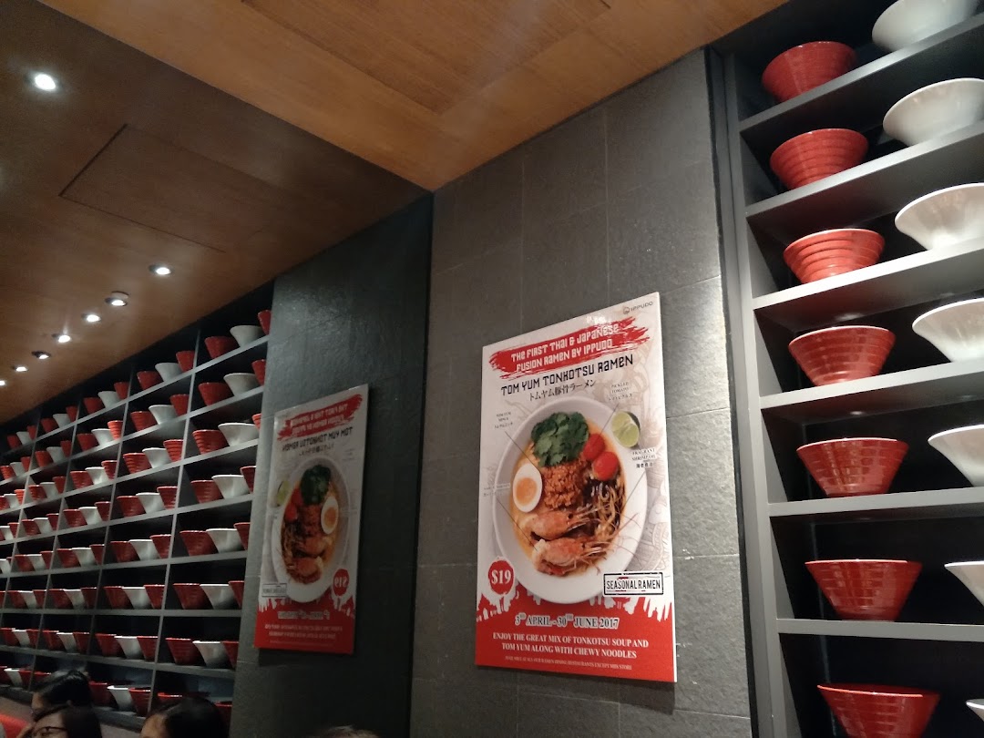 Interior view of Ippudo, showcasing a decorative wall of ramen bowls and promotional posters for seasonal ramen.