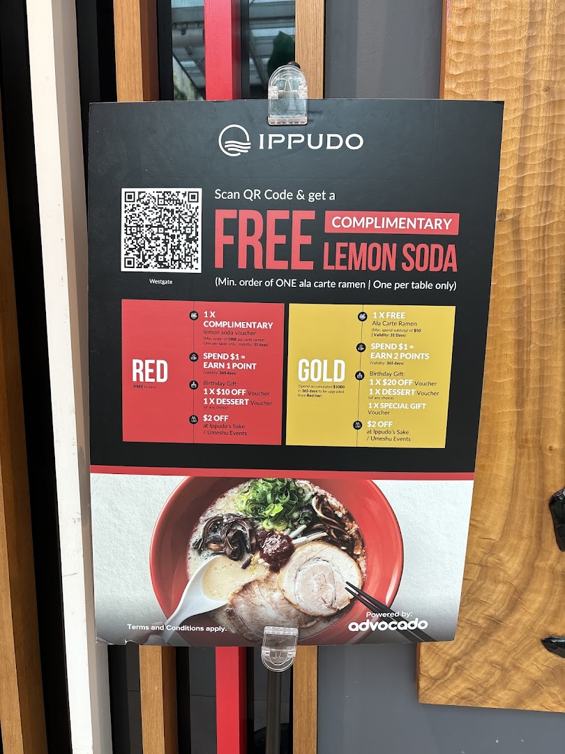 A promotional sign for Ippudo, showcasing a ramen bowl and details of their loyalty program offers.