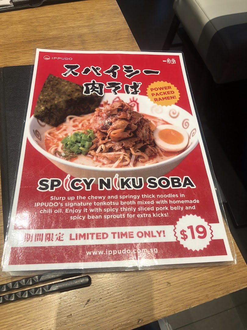 A menu card featuring Ippudo's Spicy Niku Soba ramen with its description and price.