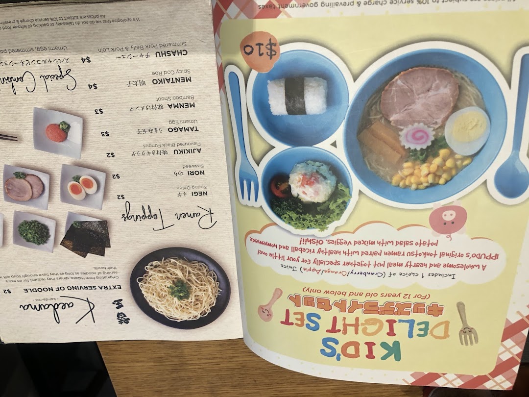 A detailed menu page from IPPUDO, featuring kids' meals, ramen toppings, and noodle add-ons.