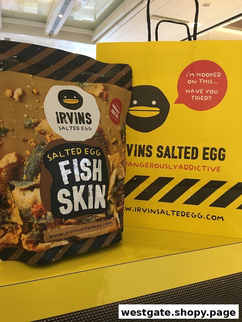 A bag of Irvins Salted Egg Fish Skin product next to a bright yellow Irvins shopping bag.