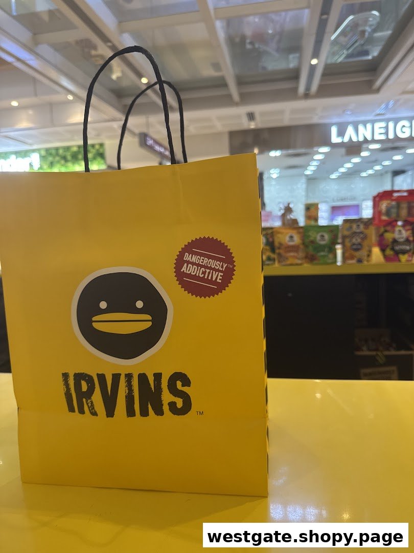 A bright yellow IRVINS shopping bag with its distinctive logo and 'Dangerously Addictive' sticker.