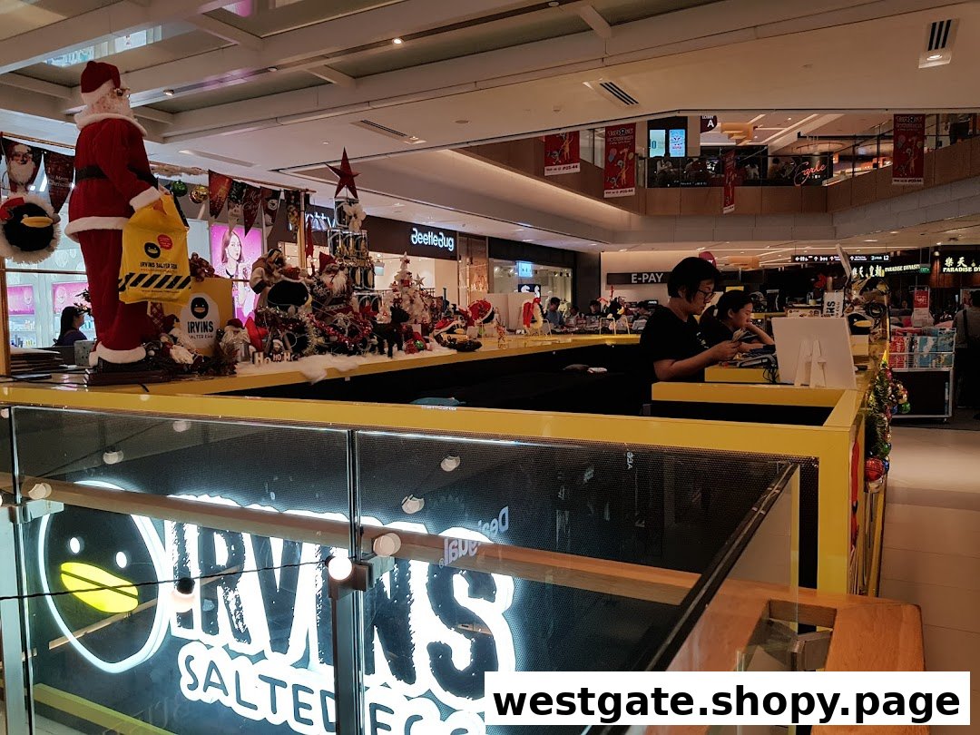 A vibrant IRVINS Salted Egg counter with staff and festive Christmas decorations in a mall setting.