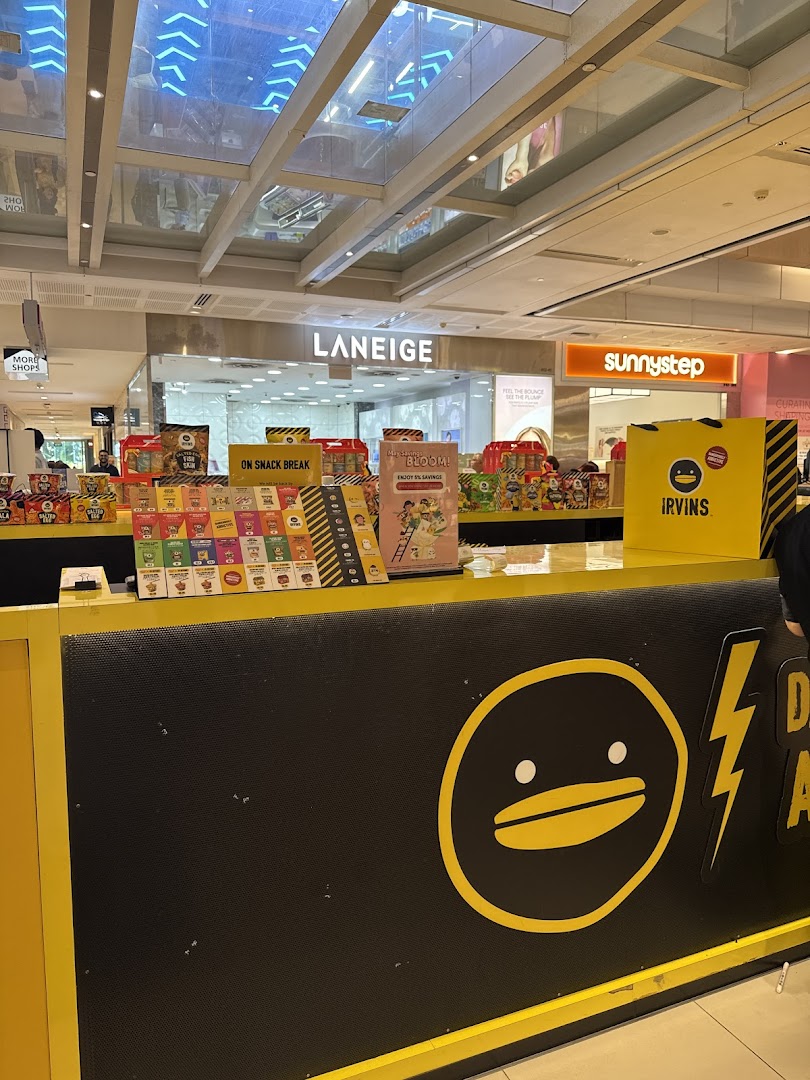 IRVINS snack counter displaying various salted egg yolk snacks and merchandise.