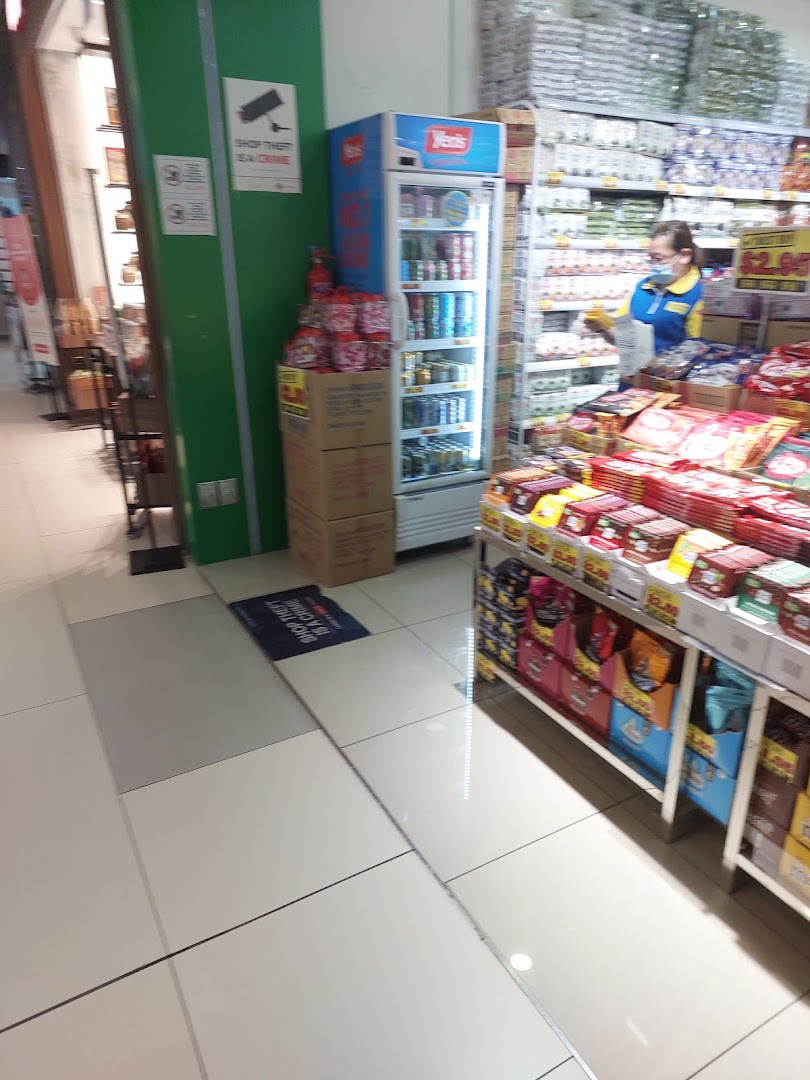 Interior view of Japan Home, showcasing various household products, a beverage cooler, and a staff member.