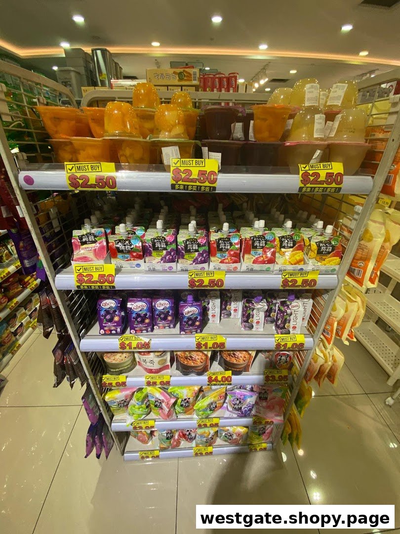 A retail shelf at Japan Home displaying various packaged snacks, drinks, and desserts with price tags.