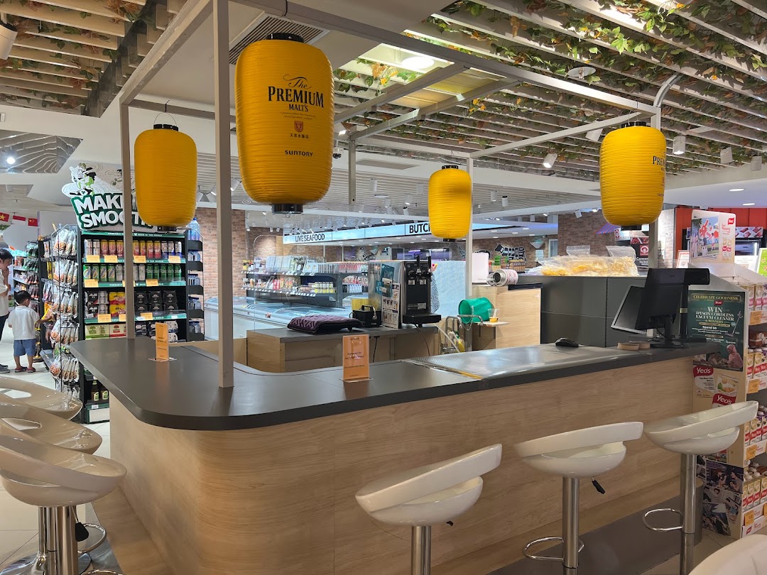 An inviting bar counter with stools and large yellow lanterns, featuring 'The Premium Malts' branding, within a retail space.