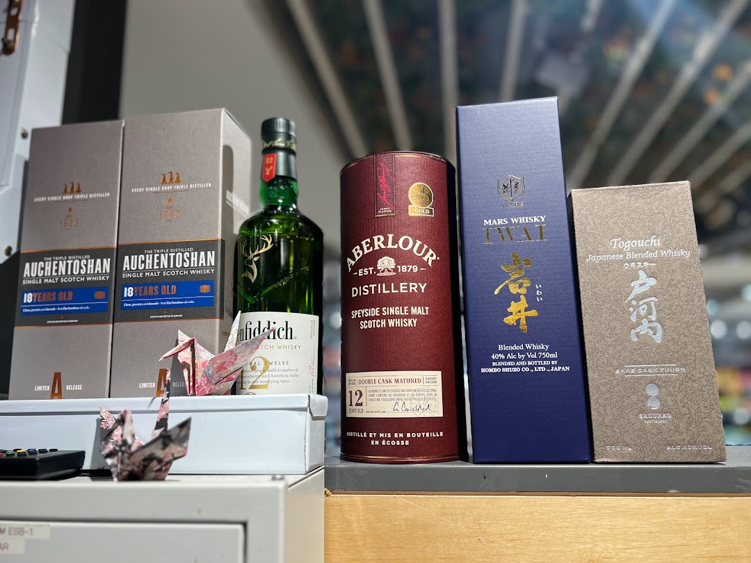 A display of various premium whisky bottles and boxes, including Scotch and Japanese blends.