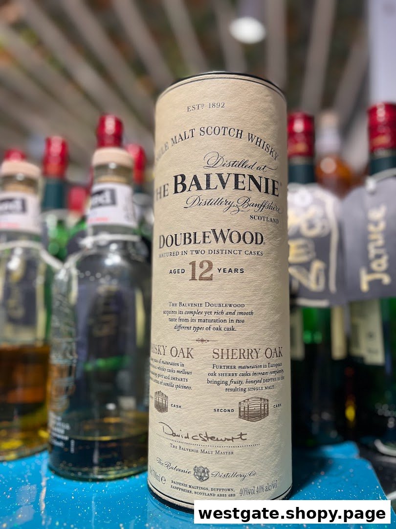 A close-up of a Balvenie DoubleWood 12 Years whisky packaging, surrounded by other bottles.