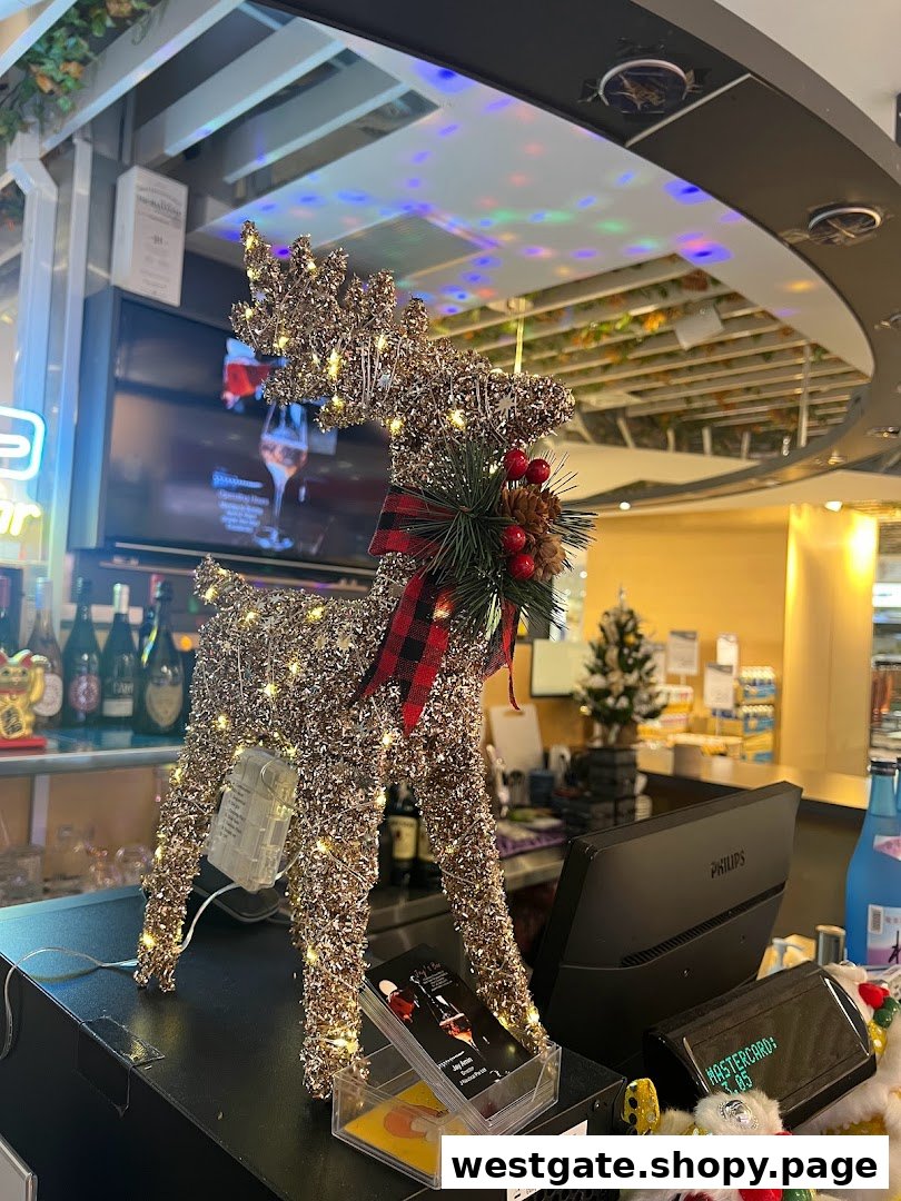 A festive, light-up reindeer decoration on a bar counter at Jays Bar, with bottles and a screen in the background.