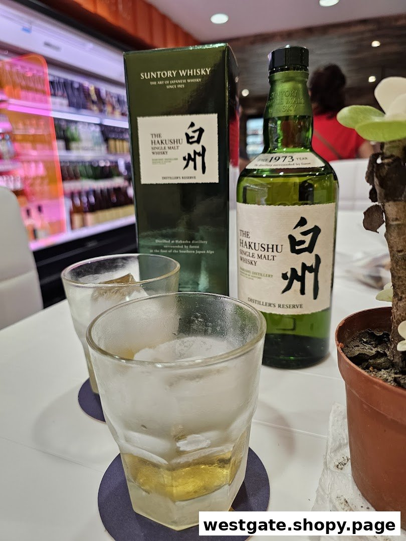 Two glasses of whisky with ice and a bottle of Suntory Hakushu on a table at Jays Bar.