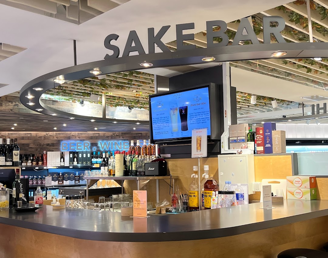 An inviting interior view of Jays Bar, featuring a well-stocked counter, Sake Bar sign, and digital display.