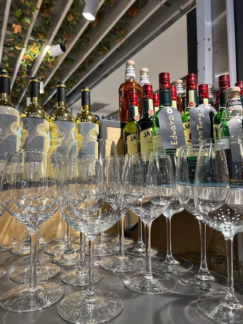 A sophisticated display of wine and liquor bottles with numerous sparkling wine glasses, ready for service.