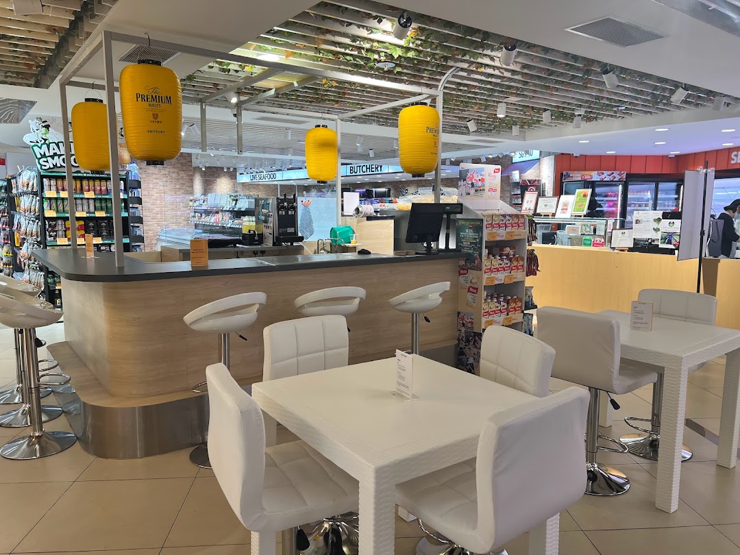 Modern food hall interior featuring a bar counter, comfortable seating, and diverse retail product displays.