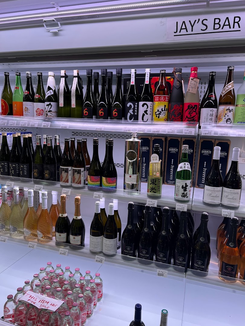 Shelves stocked with a wide variety of sake, wine, and other beverages at Jay's Bar.