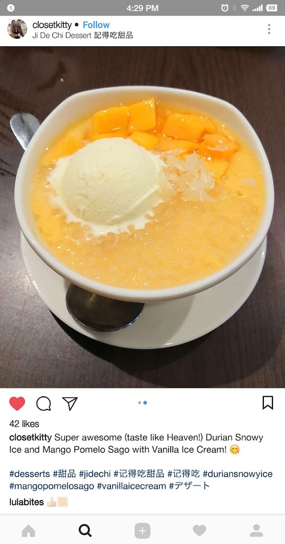 A vibrant bowl of mango pomelo sago with vanilla ice cream and fresh mango chunks.