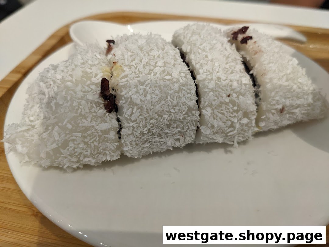 A plate of sliced white dessert covered in shredded coconut, revealing a dark filling.