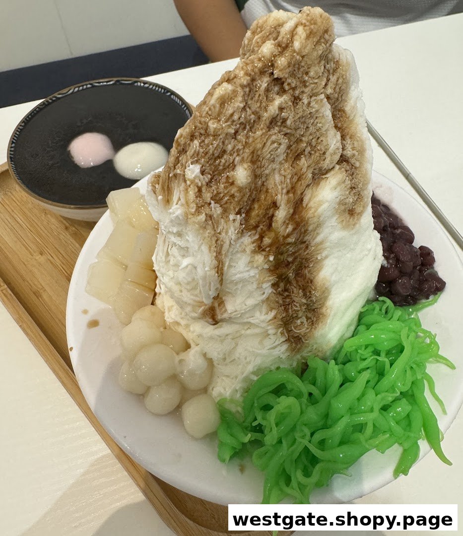 A large, refreshing shaved ice dessert with various toppings and a side of black sesame paste with mochi.