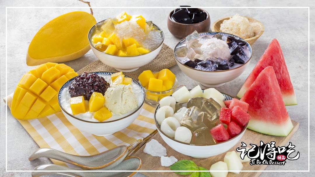 A vibrant display of various Asian fruit and jelly desserts, including mango, watermelon, and black glutinous rice.