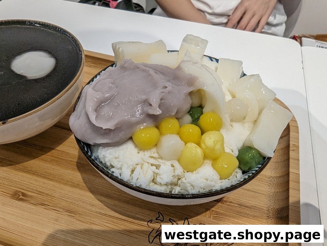 A vibrant bowl of shaved ice dessert with taro paste, various toppings, and a separate black sesame soup.