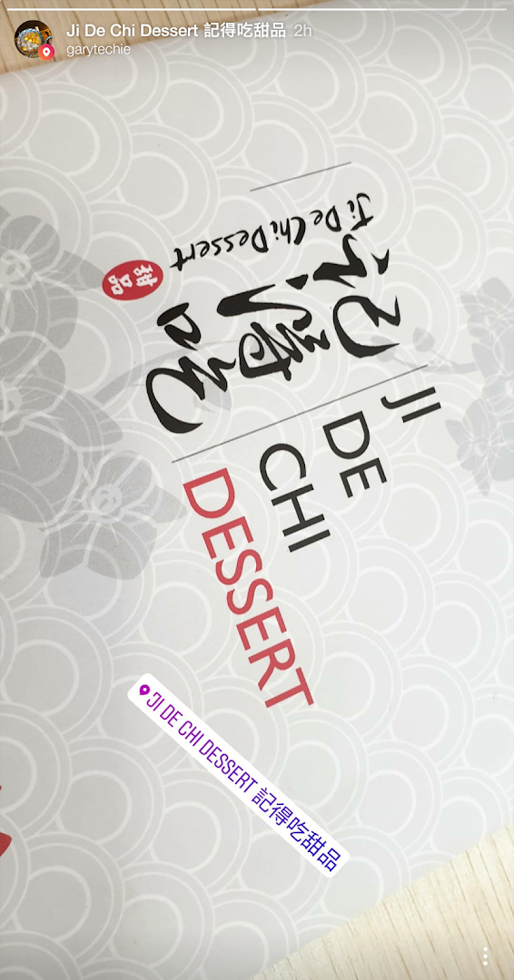 Close-up of the Ji De Chi Dessert logo and branding on a textured background.