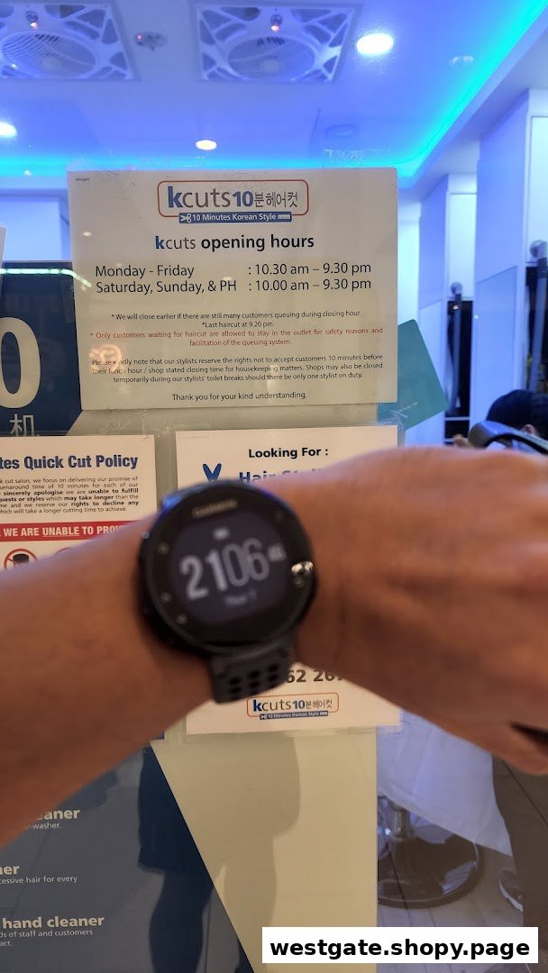 A person's arm with a smartwatch in front of kcuts opening hours and policy signs.