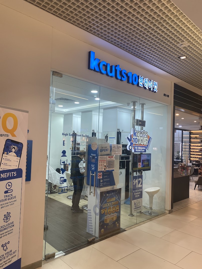 The storefront of kcuts, a hair salon offering quick Korean-style haircuts, with a customer inside.
