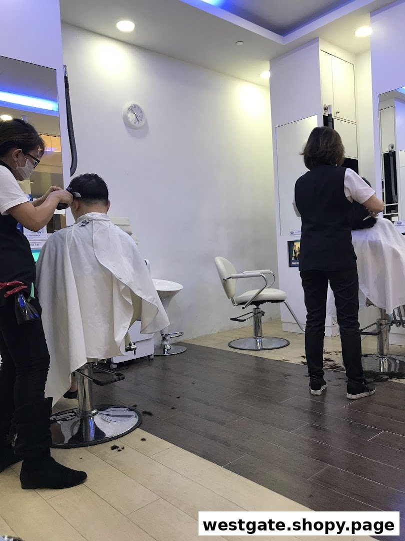 Two customers receiving haircuts from stylists inside a modern kcuts salon.