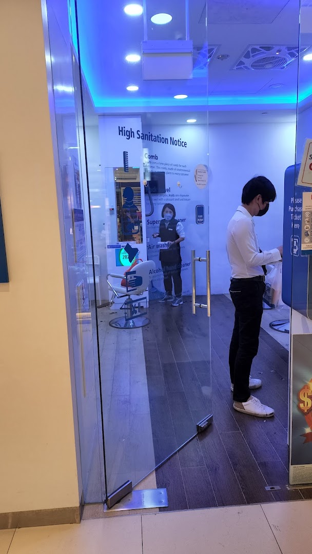 The front of kcuts Jurong Westgate, showing staff, a customer, and sanitation notices.