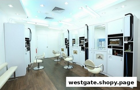 Clean, modern interior of kcuts salon with multiple white styling stations and chairs.