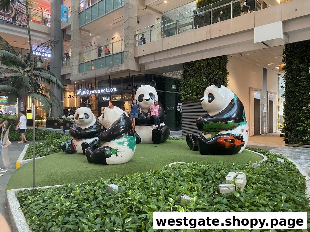 Four colorful panda statues in a green outdoor mall area with children playing.