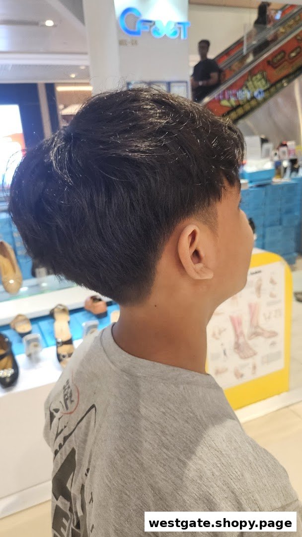 A person with a fresh haircut, seen from behind, inside a mall.