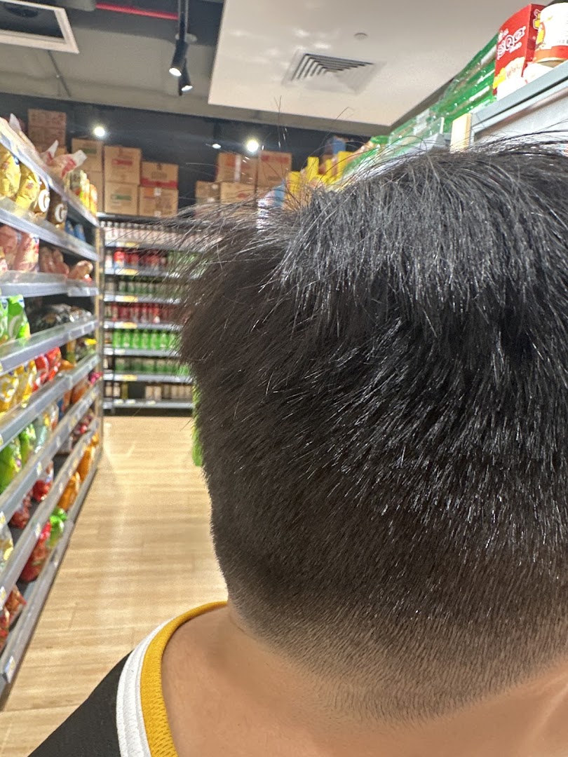 Close-up of a fresh haircut, with supermarket aisles visible in the background.