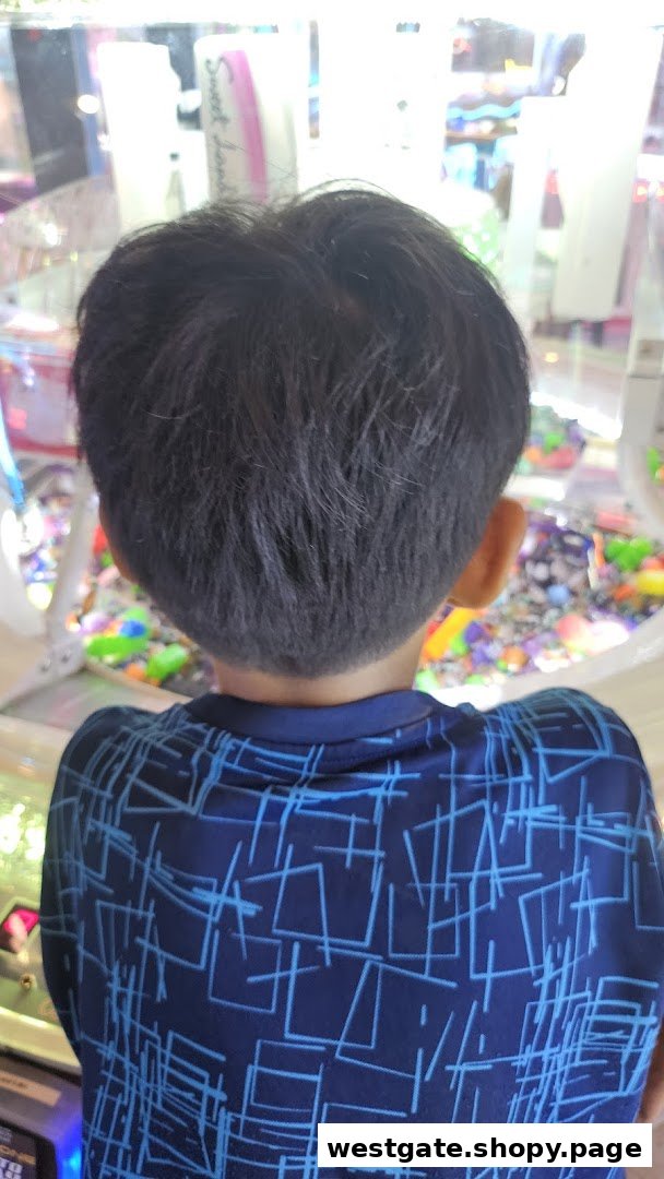 A child's back view, looking intently into an arcade game machine.