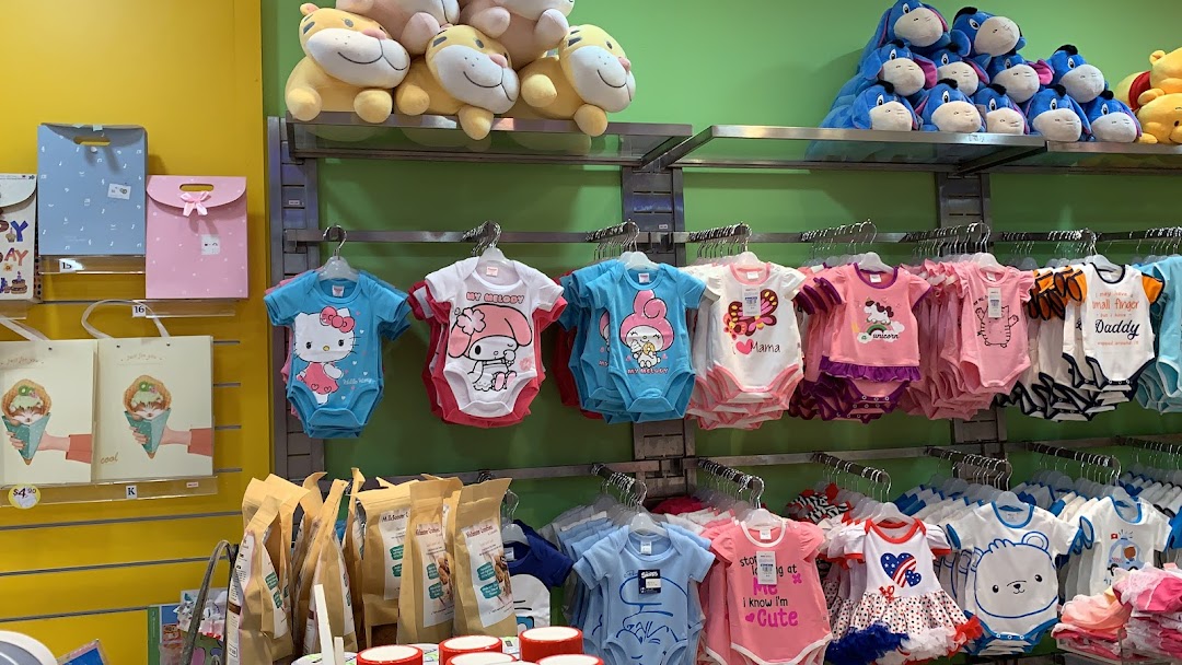 A vibrant display of baby rompers, plush toys, and gift items inside a children's store.