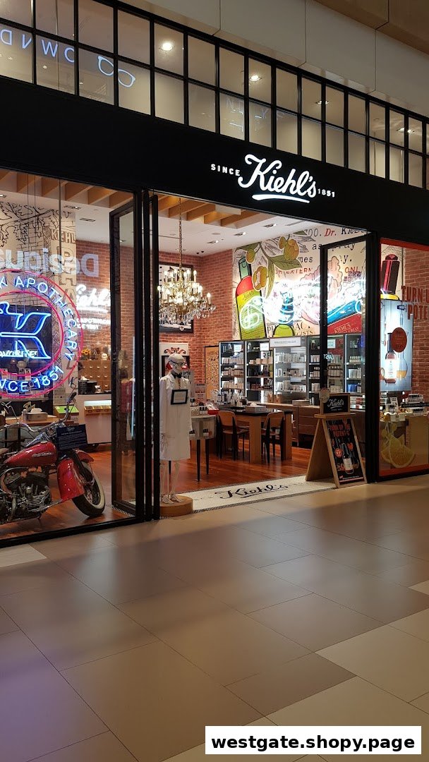 The storefront of Kiehl's, featuring a vintage motorcycle, neon sign, and a view into its apothecary-style interior.