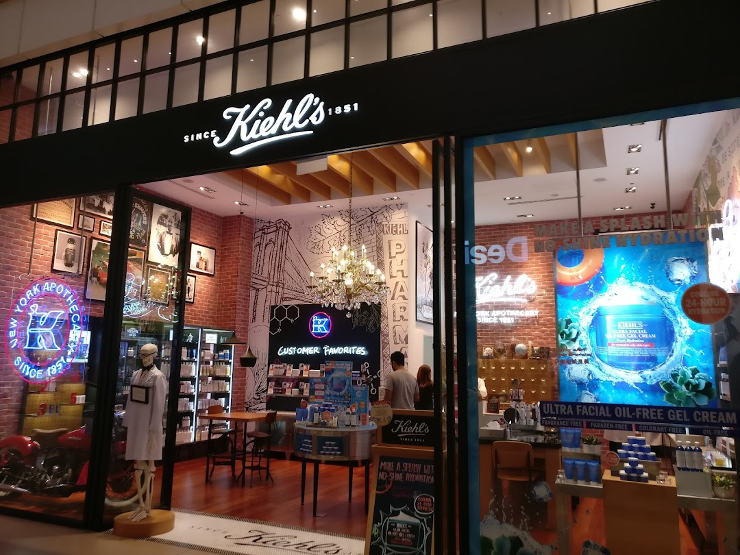 The illuminated storefront of Kiehl's at Westgate, showcasing its distinctive apothecary aesthetic and product displays.
