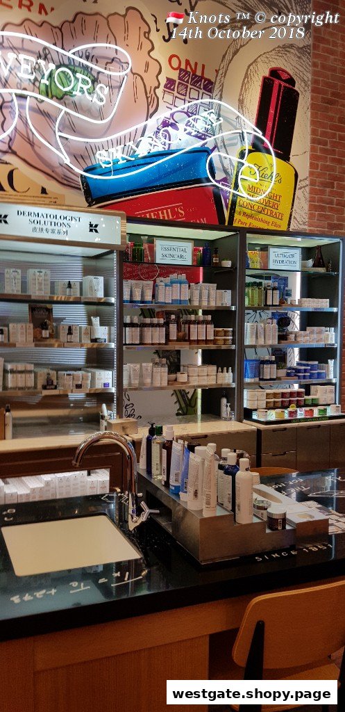 Interior view of Kiehl's showcasing skincare product displays, a prominent neon sign, and a product testing sink.